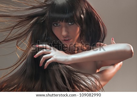 Studio creative portrait. Beautiful brunette with mess in in her hair looking into a camera