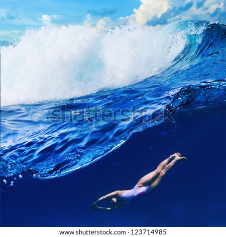 Water sport tropical background Crazy surfer girl diving under big ocean breaking wave