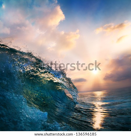 orange sunset on the beach at south summer coast and colorful blue surfing wave closing