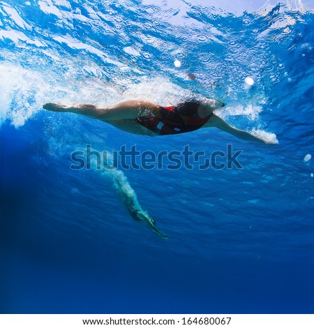 aqua sport female professional swimmers gliding underwater after the jump