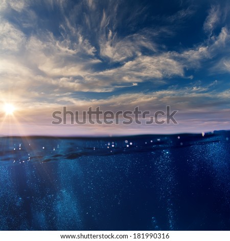 Cloudy sky with the sun split by waterline to underwater scene with bubbles as a design template.