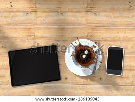 digital tablet phone and two cubes of sugar falling into a coffee cup on wooden table
