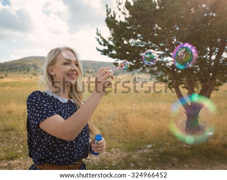 Romantic portrait of young woman with soap balloons