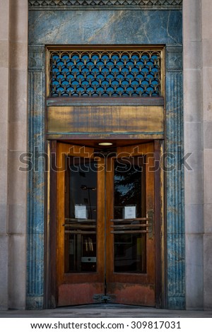 Abstract Background of a Vintage Bronze revolving door Surrounded by a weathered marble wall and grunge.