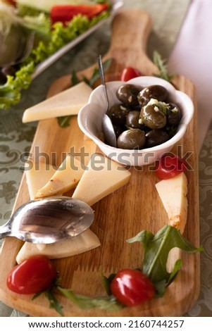 Средиземноморская диета. Ассорти из сыра на деревяной доске, оливки в белой тарелке, микс из свежих овощей Сток-фото © 
