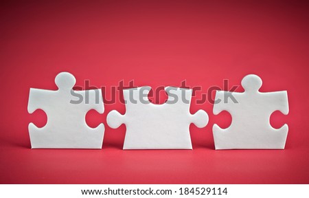 three puzzle pieces on red background