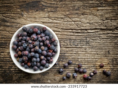 Bowl of juniper berries on old wooden table