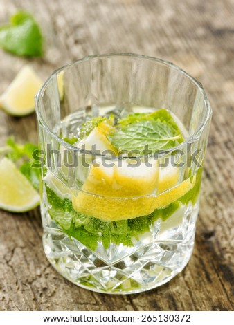 carbonated water with lemon and mint in a glass on wooden table