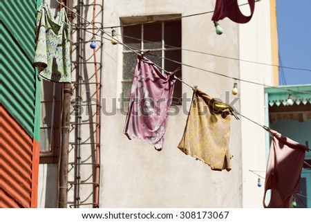 Colorful vintage clothing hanging to dry on a line under the sun in La Boca, Buenos Aires, Argentina.