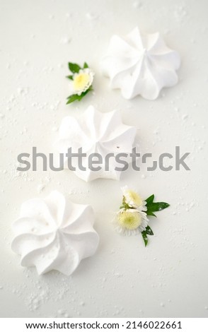 White meringues on a white background with white flowers Foto d'archivio © 