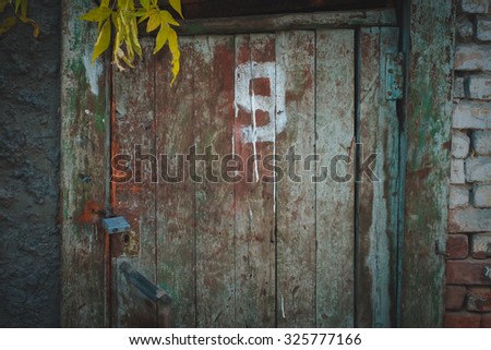 Old wooden door with the number in the evening. The texture and color of the door.
