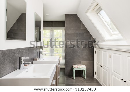 Small modern bathroom with double sink and dark tiles