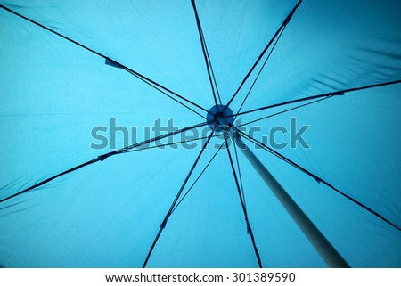inside a big blue umbrella in the sunny day