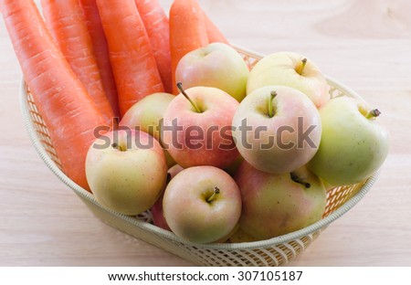 Carrots and apples in a basket with white background