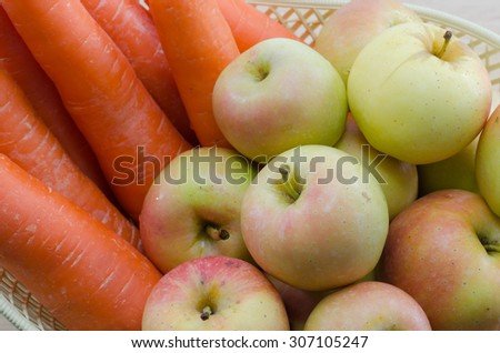 Carrots and apples in a basket with white background