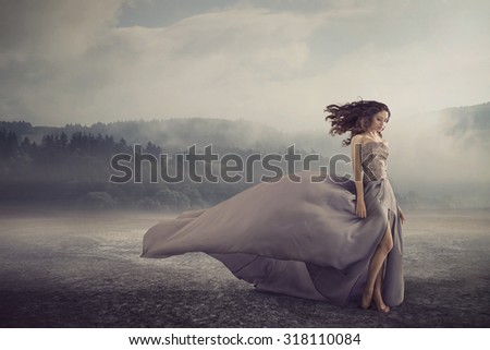 Magical brunette lady on a foggy field