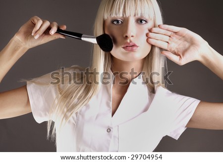Attractive blonde with face powder brush