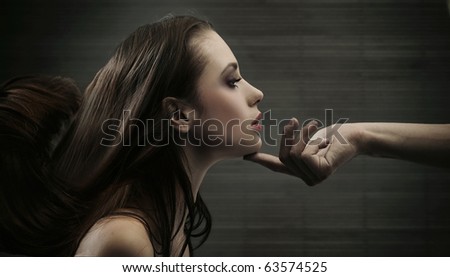 Conceptual image of a hand holding a woman\'s head
