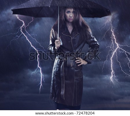 Single woman wearing coat holding umbrella. Creative symbol of the bad weather