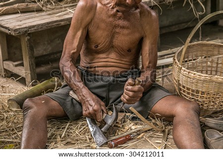 Asian man running a local carpenter made of bamboo.Young, old