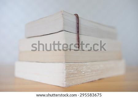 Bookworm. Real earthworm hanging over books on wooden table