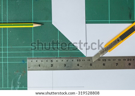 Cutter , wood pencil and ruler on old green rubber pad background