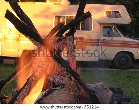 Campfire in front of camper trailer