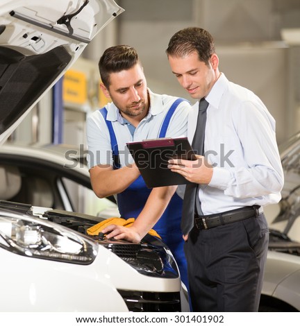 Auto mechanic and technician working in repair shop.