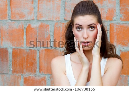 surprised fashion woman in front of a brick wall