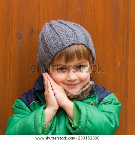 cute kid with against wood wall in the background