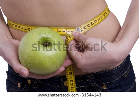 Fit woman with measure tape isolated over white. Weight loss and healthy lifestyle concept. Girl measuring waist with a tape measure. Isolated. Woman hold apple in hand. Waist is 65.5 centimeters.