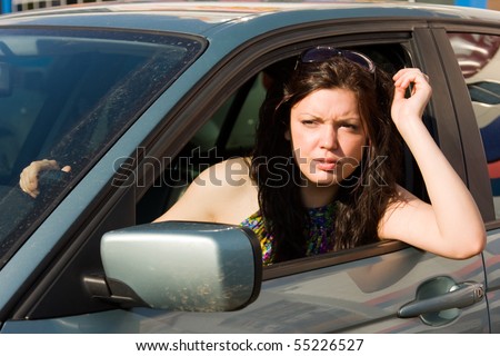 Happy young driver portrait. Woman is sitting in the driver\'s seat of a car.