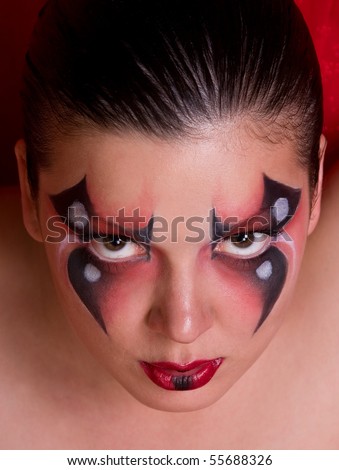 Face of a woman with body paint as spider.  Female eye with red-black beauty fashion make-up