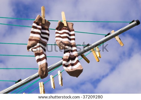 A pair of freshly washed socks hang out to dry on a sunny day