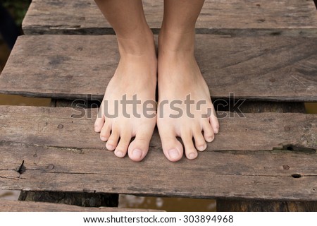 women\'s feet on the old wooden bridge for input some message