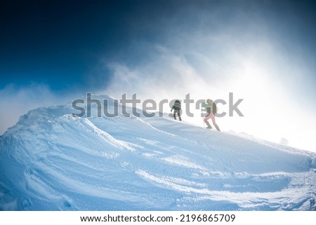 Image, Stock Photo Two mountaineers climb a summit with a summit cross in heavy snowfall. There is no room at the summit cross.