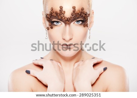 Portrait of beautiful girl with trendy make-up with coffee beans. Body painting.