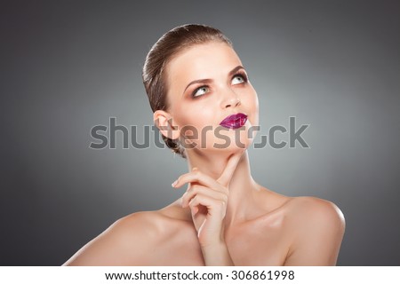 beautiful girl touches her face. thinking about something. close-up studio portrait. youth and health. skin care.
