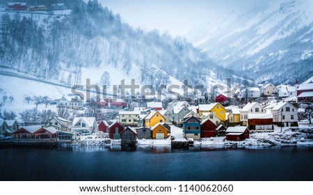 wooden houses on the banks of the Norwegian fjord, beautiful mountain landscape in winter