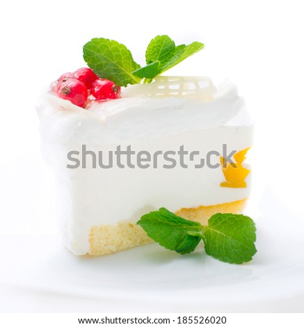 tasty cheesecake with berries red currant and mint leaves on white background