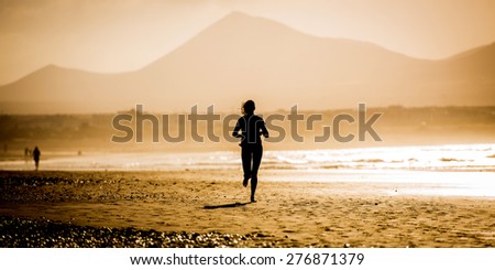 Silhouette of the woman, running on the beach