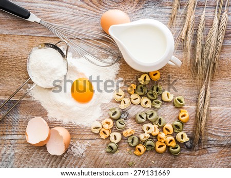 Tortellini with other products on a wooden flour board