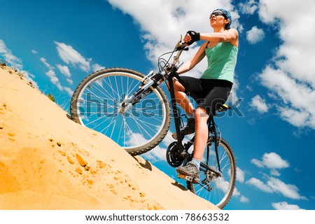 bikecyclist  in the desert against blue sky