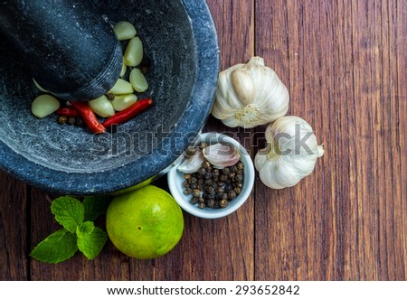 Garlic bulbs and cloves with stone Pestle and mortar on a wooden table