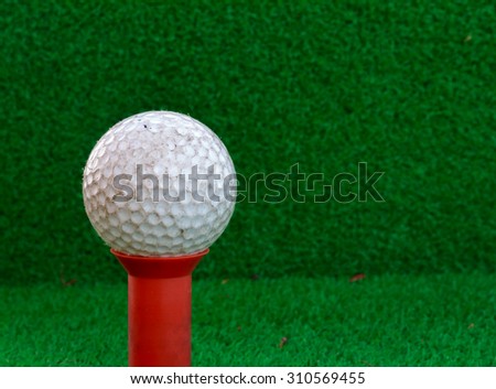 Golf ball,tee on the blur grass background.