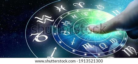 Astrological zodiac signs inside of horoscope circle. Man or Woman touching screen Zodiac signs hologram. Astrology concept.
