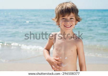child draws smile on your body with sunscreen protection