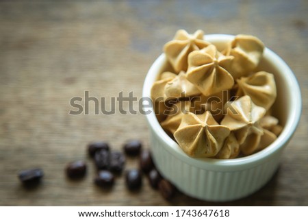 Close up Meringue coffee in a white ceramic bowl on a wooden rustic table with coffee beans blank for copy space. Foto d'archivio © 