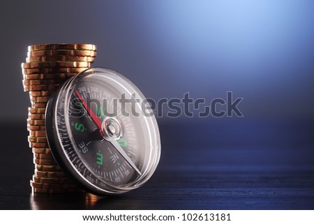 Stack of coins next to Compass