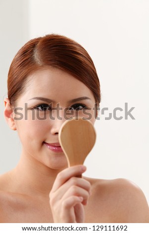 Young woman holding mirror on the white background